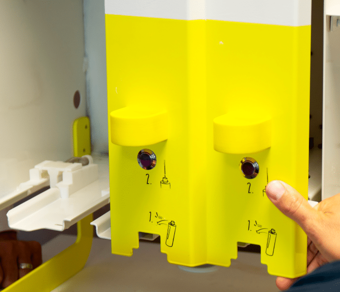 : Un prototype de produit jaune avec des composants numérotés et annotés pour démonstration et évaluation, tenu par une main, reflétant l'étape de prototypage.